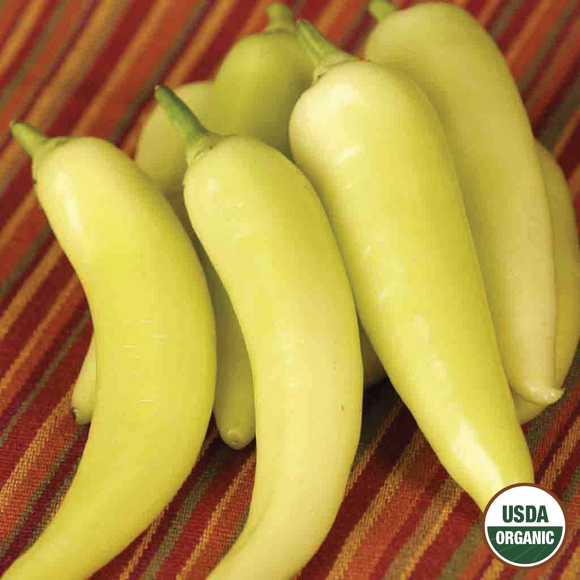 A cluster of yellow Sweet Banana Peppers with the USDA Organic label, displayed on a striped red and orange background.